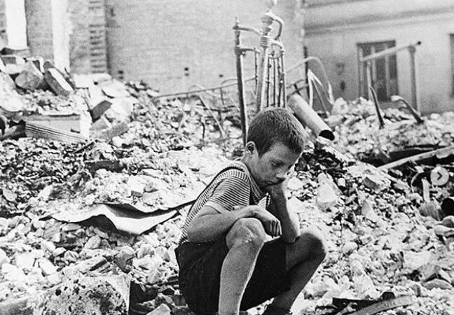 Uma criança em meio aos escombros de uma cidade destruída na Segunda Guerra